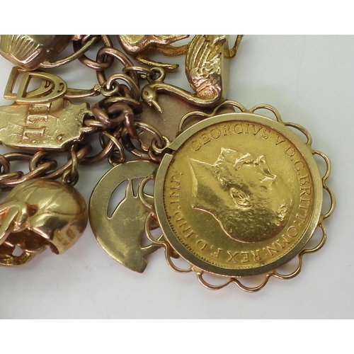 750 - A 9ct gold charm bracelet, with a 1911 full gold sovereign in 9ct pendant mount, nineteen 9ct charms... 