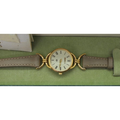 A ladies gold plated Gucci watch number 6000L with serial number 0100476 with box and point of sale