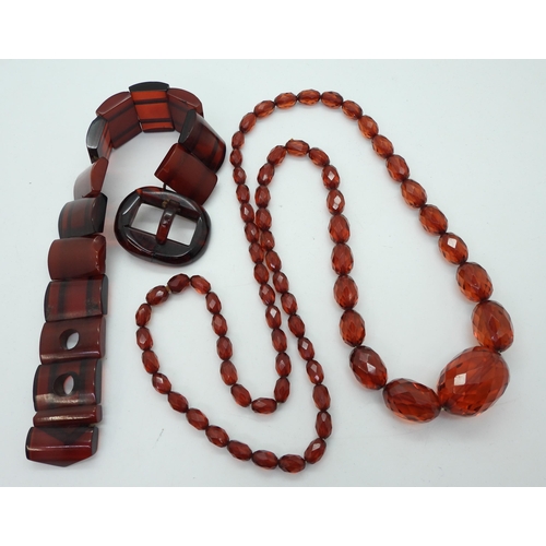 947 - A cherry amber coloured buckle bracelet, length 24.5cm, weight 39gms, together with a long string of... 