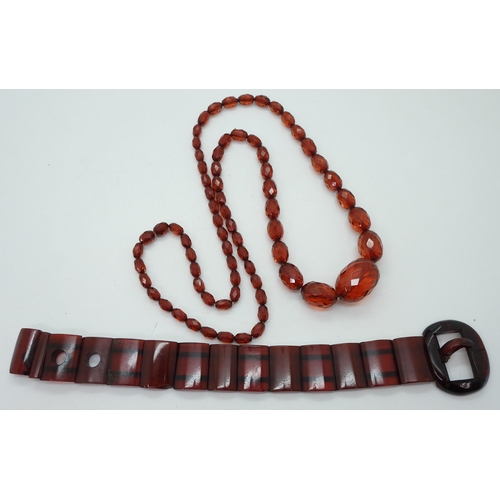 947 - A cherry amber coloured buckle bracelet, length 24.5cm, weight 39gms, together with a long string of... 