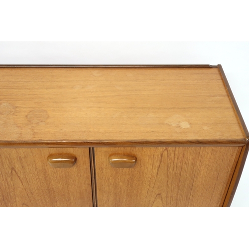 2103 - A MID 20TH CENTURY TEAK PORTWOOD SIDEBOARD with three drawers flanked by fall front drinks compartme... 