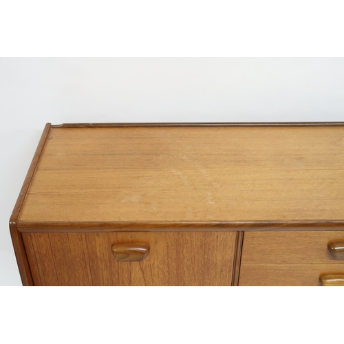 2103 - A MID 20TH CENTURY TEAK PORTWOOD SIDEBOARD with three drawers flanked by fall front drinks compartme... 