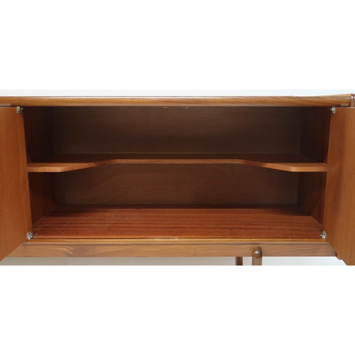 2103 - A MID 20TH CENTURY TEAK PORTWOOD SIDEBOARD with three drawers flanked by fall front drinks compartme... 