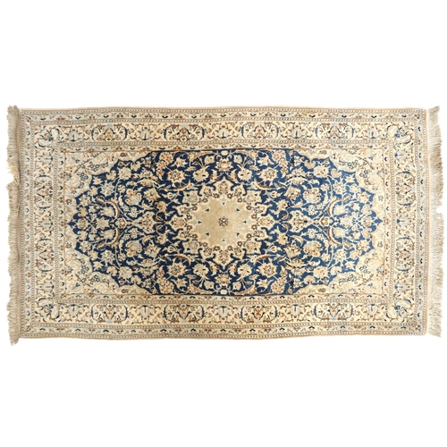 2170 - A DARK BLUE GOUND FINE PILE NAIN RUG mounted to bamboo wall rail with ivory and beige central medall... 