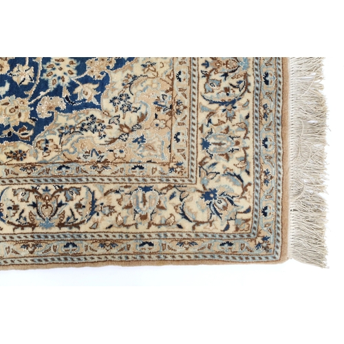 2170 - A DARK BLUE GOUND FINE PILE NAIN RUG mounted to bamboo wall rail with ivory and beige central medall... 