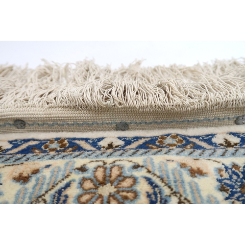 2172 - A CREAM GROUND FINE PILE NAIN RUG mounted to wall rail with floral/foliate patterned central medalli... 