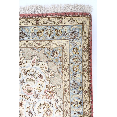 2173 - AN IVORY GROUND FINE PILE SILK SIGNED QUM RUGwith blue and beige sunburst central medallion and matc... 