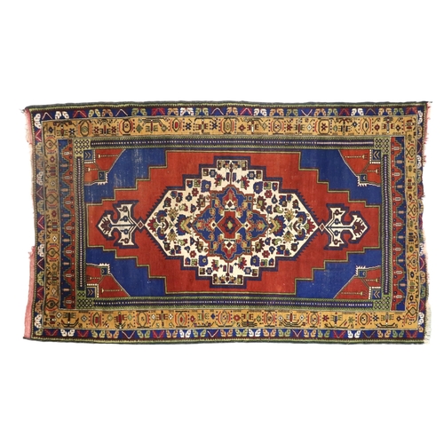 2176 - A RED GROUND TURKISH KASPINAR RUG with multicoloured geometric floral patterned central medallion an... 