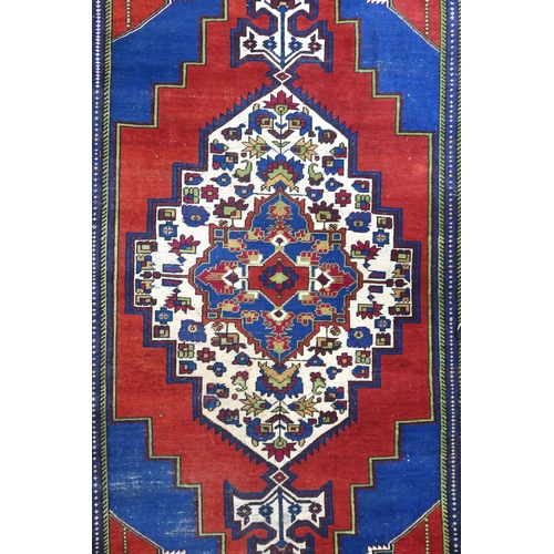 2176 - A RED GROUND TURKISH KASPINAR RUG with multicoloured geometric floral patterned central medallion an... 