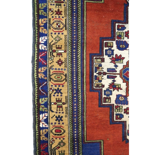 2176 - A RED GROUND TURKISH KASPINAR RUG with multicoloured geometric floral patterned central medallion an... 