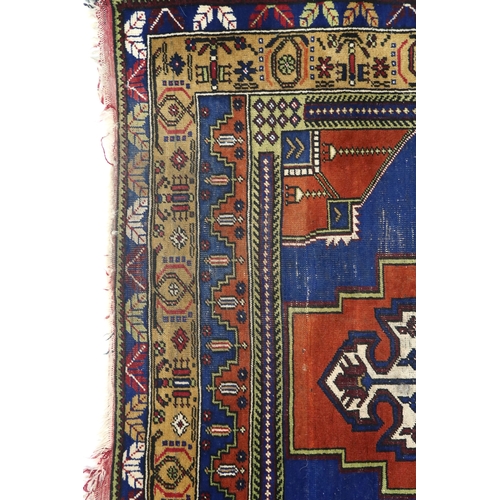 2176 - A RED GROUND TURKISH KASPINAR RUG with multicoloured geometric floral patterned central medallion an... 