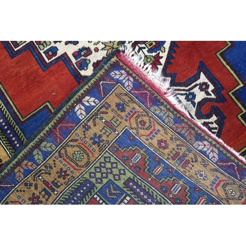 2176 - A RED GROUND TURKISH KASPINAR RUG with multicoloured geometric floral patterned central medallion an... 