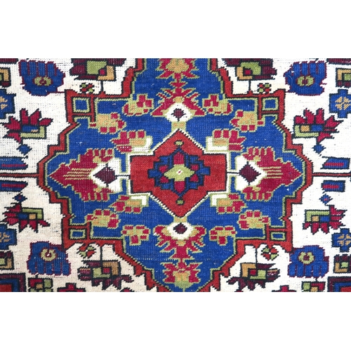 2176 - A RED GROUND TURKISH KASPINAR RUG with multicoloured geometric floral patterned central medallion an... 