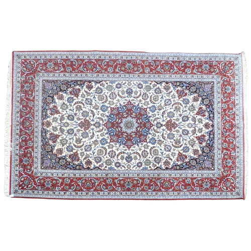 2177 - AN IVORY GROUND FULL PILE PERSIAN ISFAHAN CARPET with red central medallion and dark blue spandrels ... 