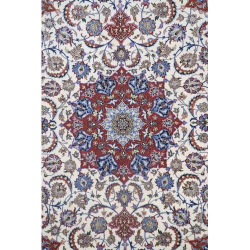 2177 - AN IVORY GROUND FULL PILE PERSIAN ISFAHAN CARPET with red central medallion and dark blue spandrels ... 