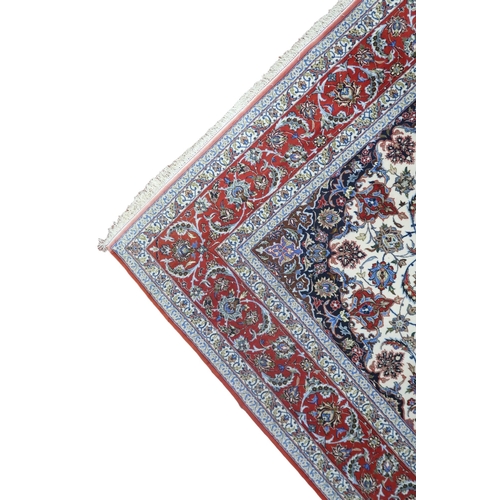 2177 - AN IVORY GROUND FULL PILE PERSIAN ISFAHAN CARPET with red central medallion and dark blue spandrels ... 