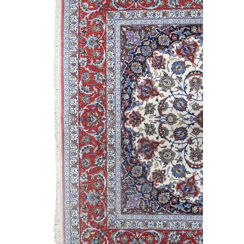 2177 - AN IVORY GROUND FULL PILE PERSIAN ISFAHAN CARPET with red central medallion and dark blue spandrels ... 