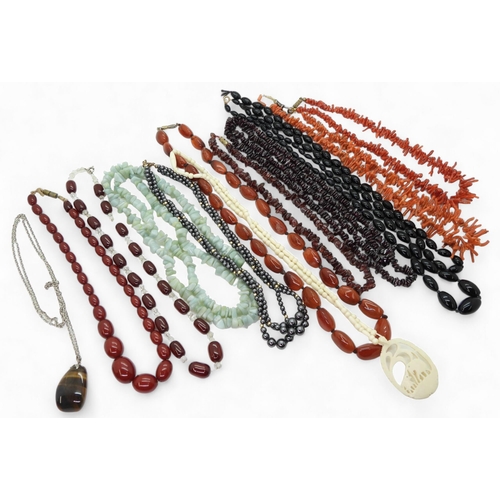 898 - Two strings of red cherry amber beads, together with further examples of gem-set beaded necklaces, i... 