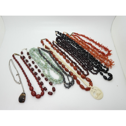 898 - Two strings of red cherry amber beads, together with further examples of gem-set beaded necklaces, i... 