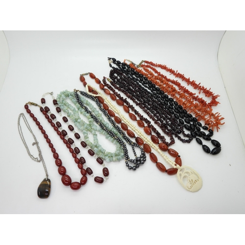 898 - Two strings of red cherry amber beads, together with further examples of gem-set beaded necklaces, i... 