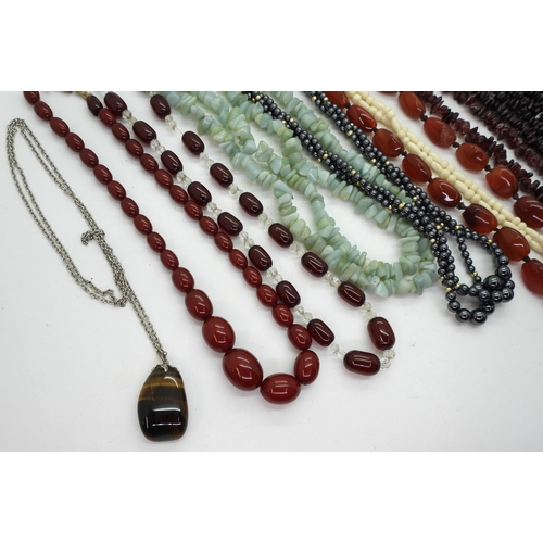 898 - Two strings of red cherry amber beads, together with further examples of gem-set beaded necklaces, i... 