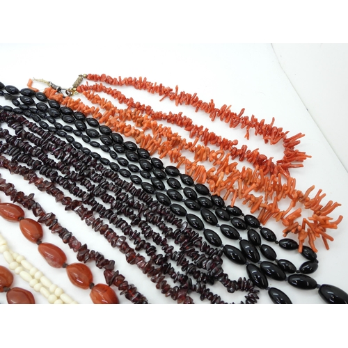 898 - Two strings of red cherry amber beads, together with further examples of gem-set beaded necklaces, i... 