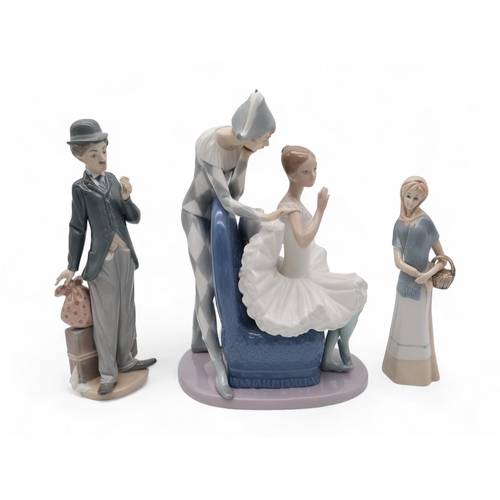 217 - A Nao figure of a ballerina and jester, a Llladro figure of Charlie Chaplin, two Nao playing dog gro... 
