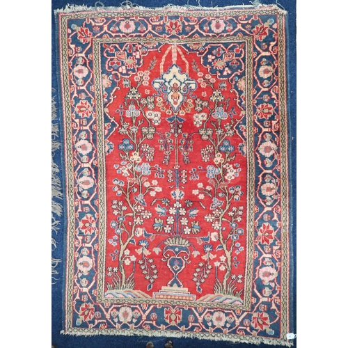 39 - A red ground Persian style tree of life patterned rug with blue floral borders, 192cm long x 133cm w... 