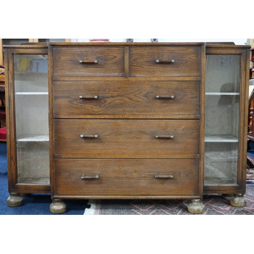 42 - An early 20th century oak chest with two short over three long drawers flanked by pair of glazed doo... 