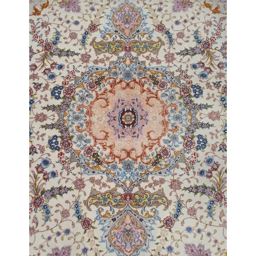 91 - A cream ground fine pile Isfahan rug with multicoloured central medallion and spandrels on floral pa... 