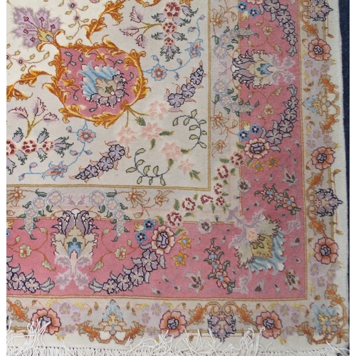 91 - A cream ground fine pile Isfahan rug with multicoloured central medallion and spandrels on floral pa... 