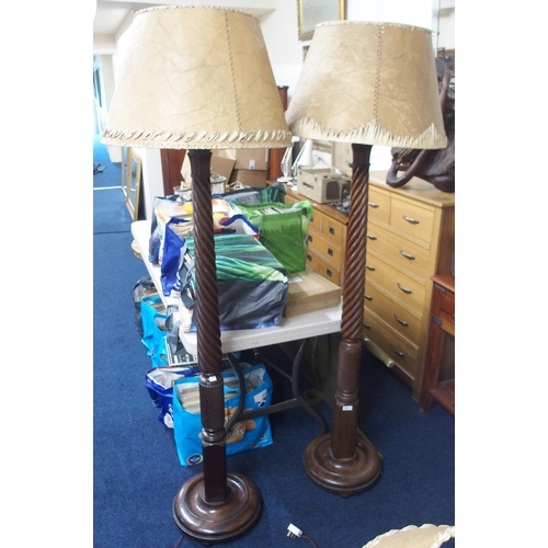 121 - A pair of 20th century mahogany barley twist standard lamps with animal hide shades on circular base... 