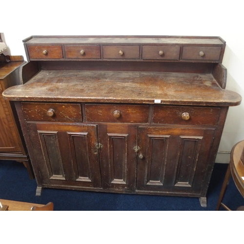 128 - An early 20th century stained pine kitchen dresser with five drawer superstructure over unit with th... 