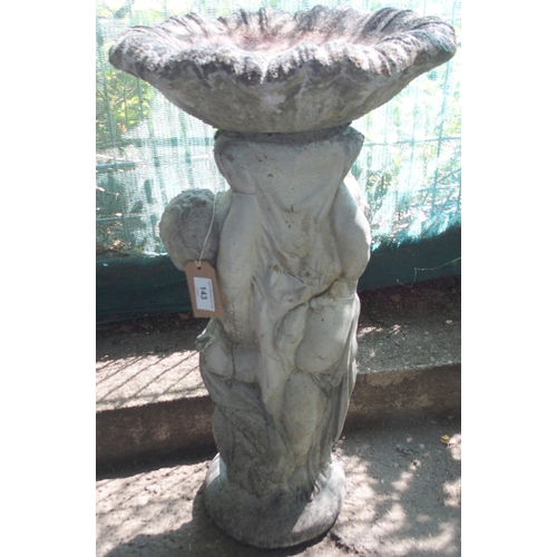 143 - A 20th century reconstituted stone garden birdbath modelled as a pair of cherubim figures supporting... 