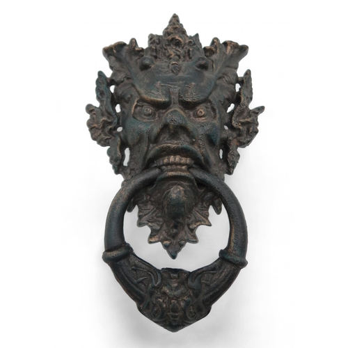 207 - A large cast iron door knocker modelled as a grotesque mask, 33cm high