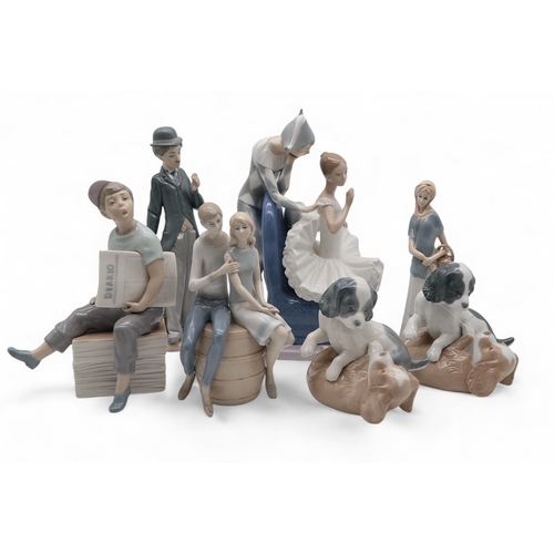 217 - A Nao figure of a ballerina and jester, a Llladro figure of Charlie Chaplin, two Nao playing dog gro... 