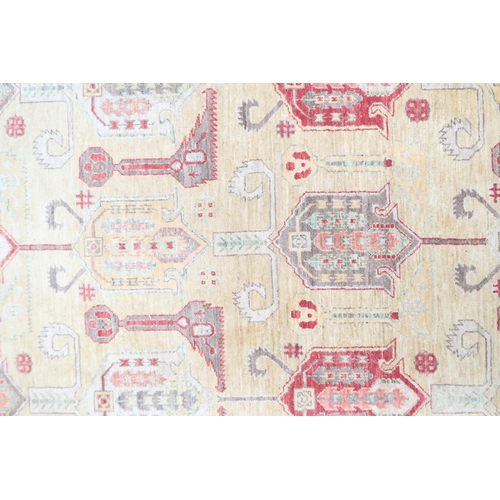 3 - A beige ground Kazak rug with multicoloured geometric patterned ground within terracotta border, 281... 