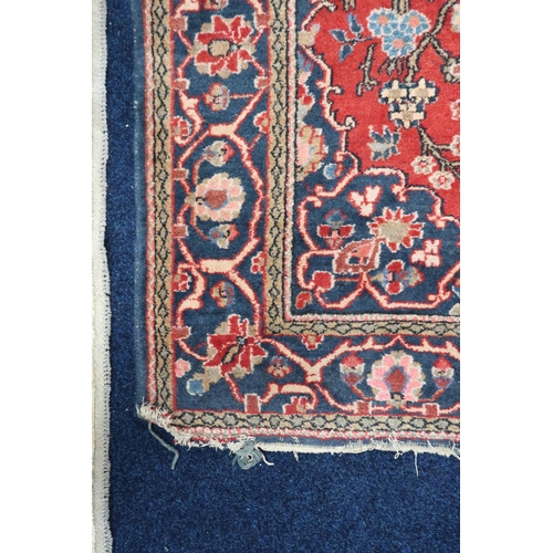 39 - A red ground Persian style tree of life patterned rug with blue floral borders, 192cm long x 133cm w... 