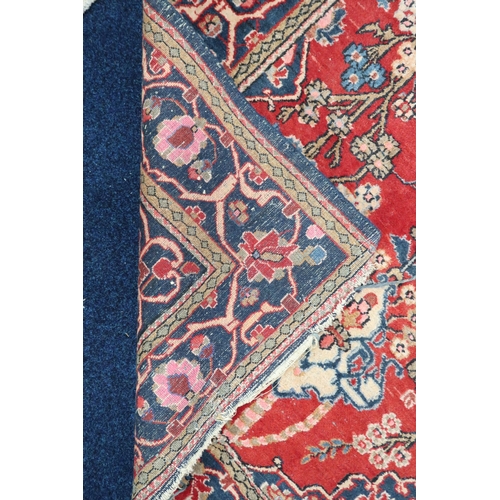 39 - A red ground Persian style tree of life patterned rug with blue floral borders, 192cm long x 133cm w... 