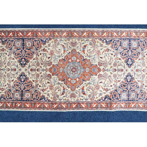 67 - An ivory ground Keshan style runner with three red diamond shaped medallions, blue spandrels on flor... 