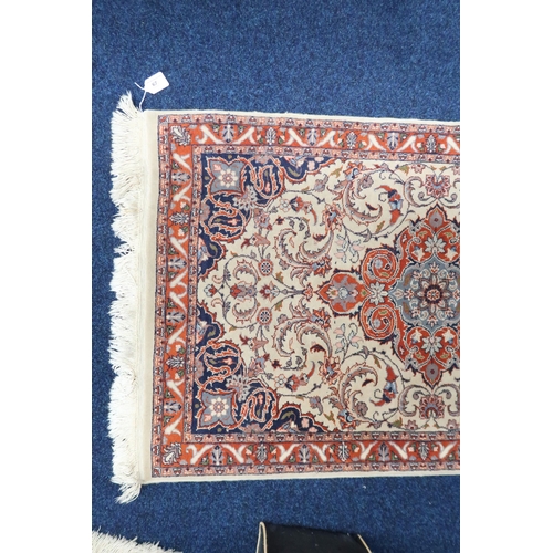 67 - An ivory ground Keshan style runner with three red diamond shaped medallions, blue spandrels on flor... 