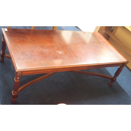 79 - A 20th century mahogany veneered coffee table on reeded supports joined by shaped crossed stretchers... 