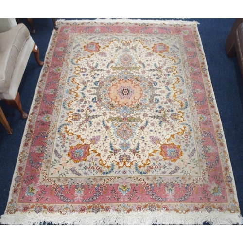 91 - A cream ground fine pile Isfahan rug with multicoloured central medallion and spandrels on floral pa... 