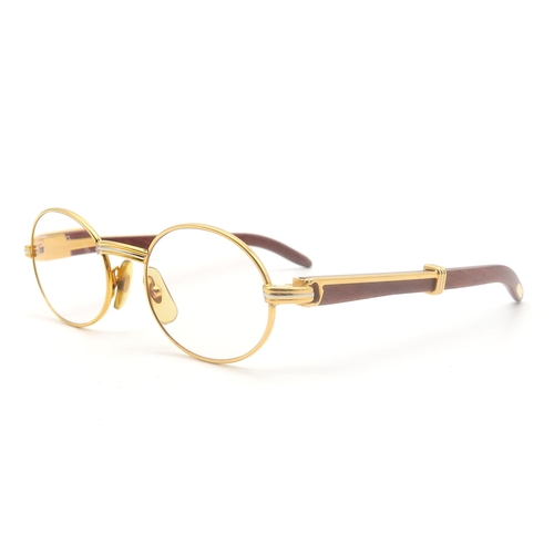 436 - A pair of Cartier gold-tone glasses, with wooden temples, the bridge marked 