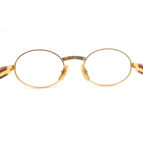 436 - A pair of Cartier gold-tone glasses, with wooden temples, the bridge marked 