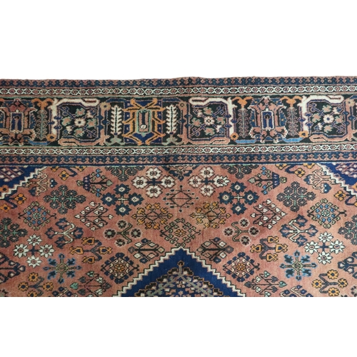 2181 - A TERRACOTTA GROUND JOSHAGAN RUG with dark blue diamond central medallion and matching spandrels on ... 