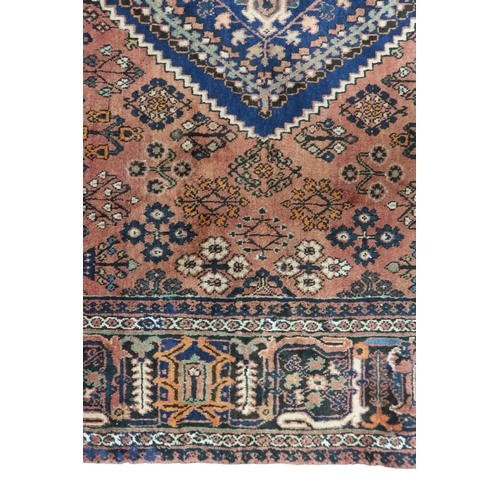 2181 - A TERRACOTTA GROUND JOSHAGAN RUG with dark blue diamond central medallion and matching spandrels on ... 