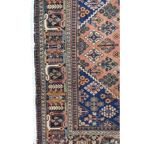 2181 - A TERRACOTTA GROUND JOSHAGAN RUG with dark blue diamond central medallion and matching spandrels on ... 