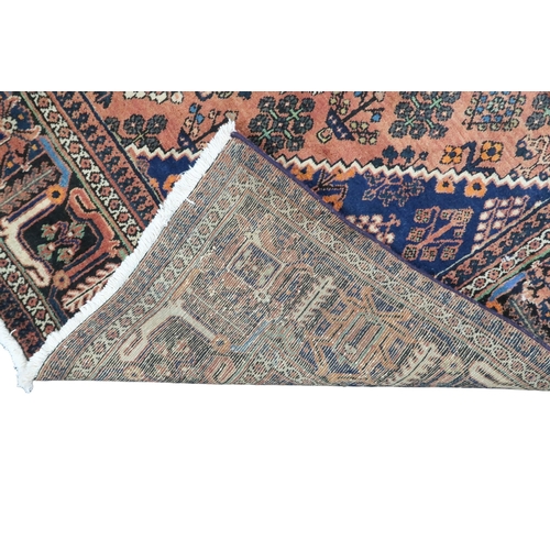 2181 - A TERRACOTTA GROUND JOSHAGAN RUG with dark blue diamond central medallion and matching spandrels on ... 