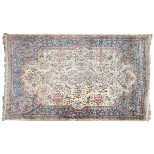 2183 - AN IVORY GROUND AUBUSSON STYLE RUG with multicoloured floral patterned ground within shaped blue flo... 